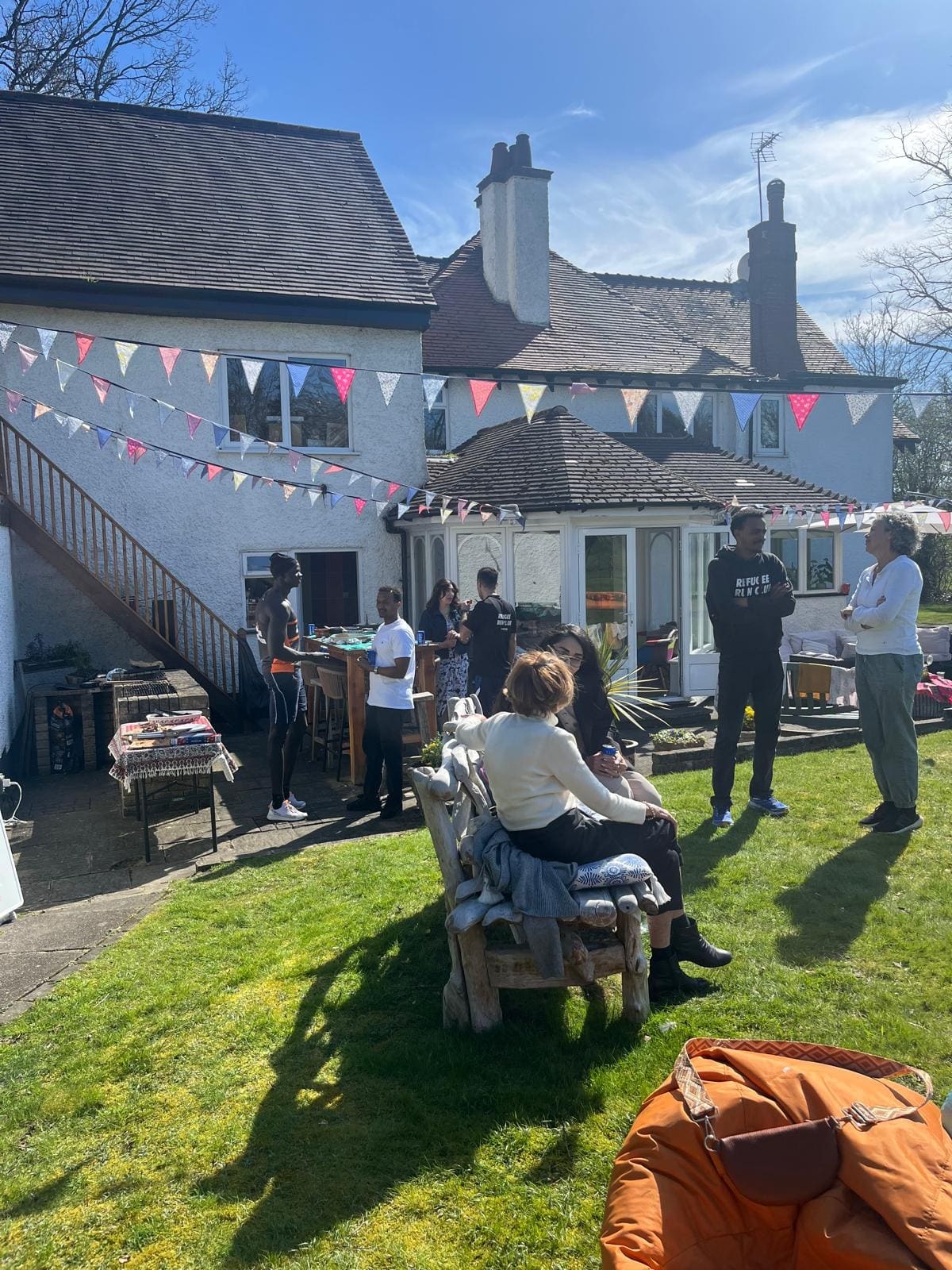 The garden in the sunshine, with bunting across the house