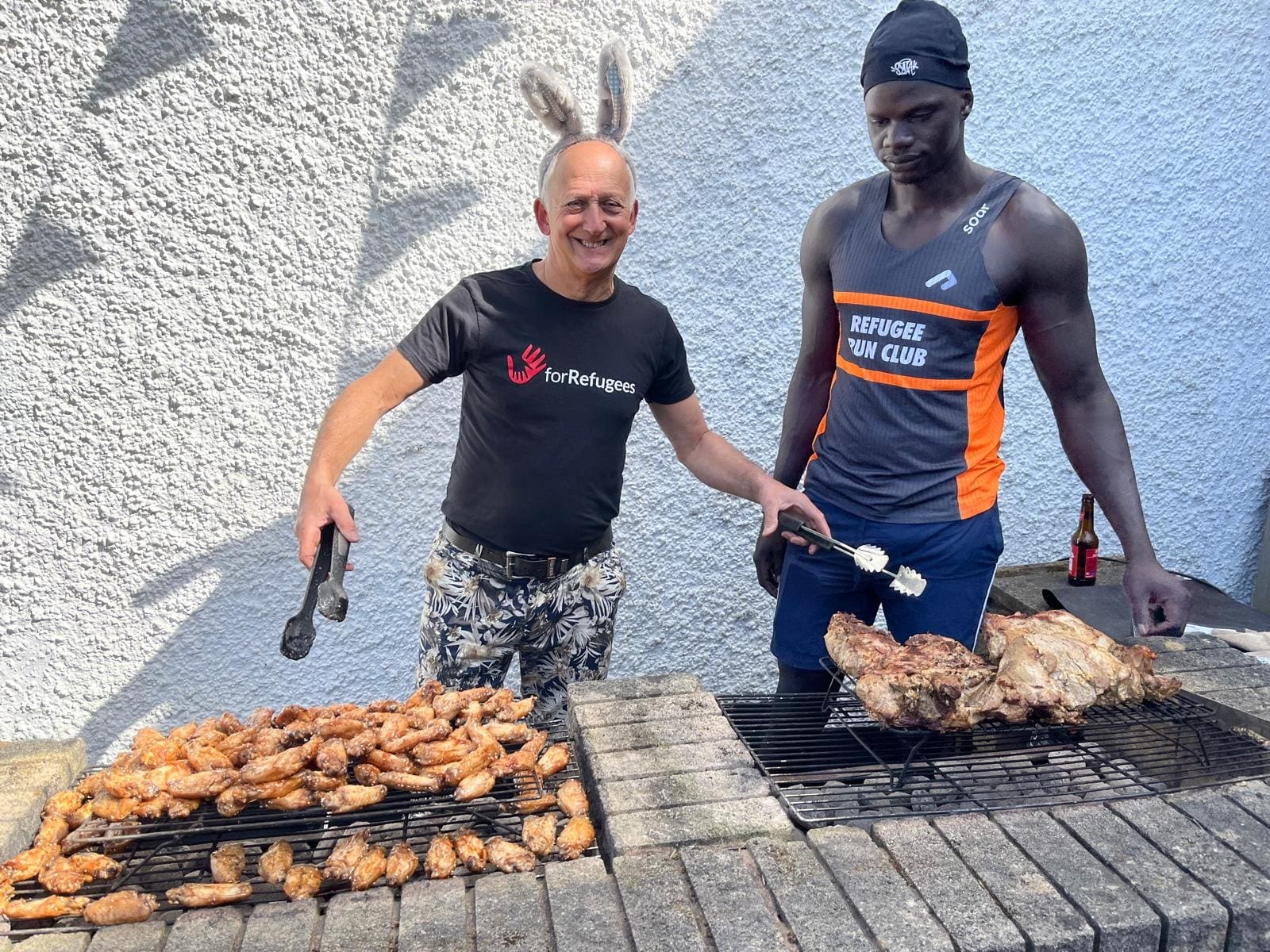 At the grill, with trays of chicken cooking