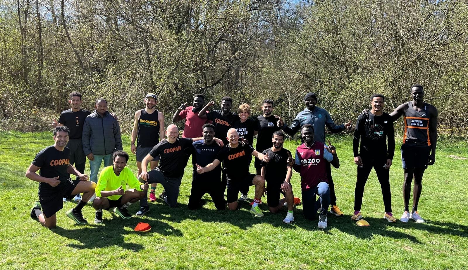 The Refugee Run Club on the grass after a run