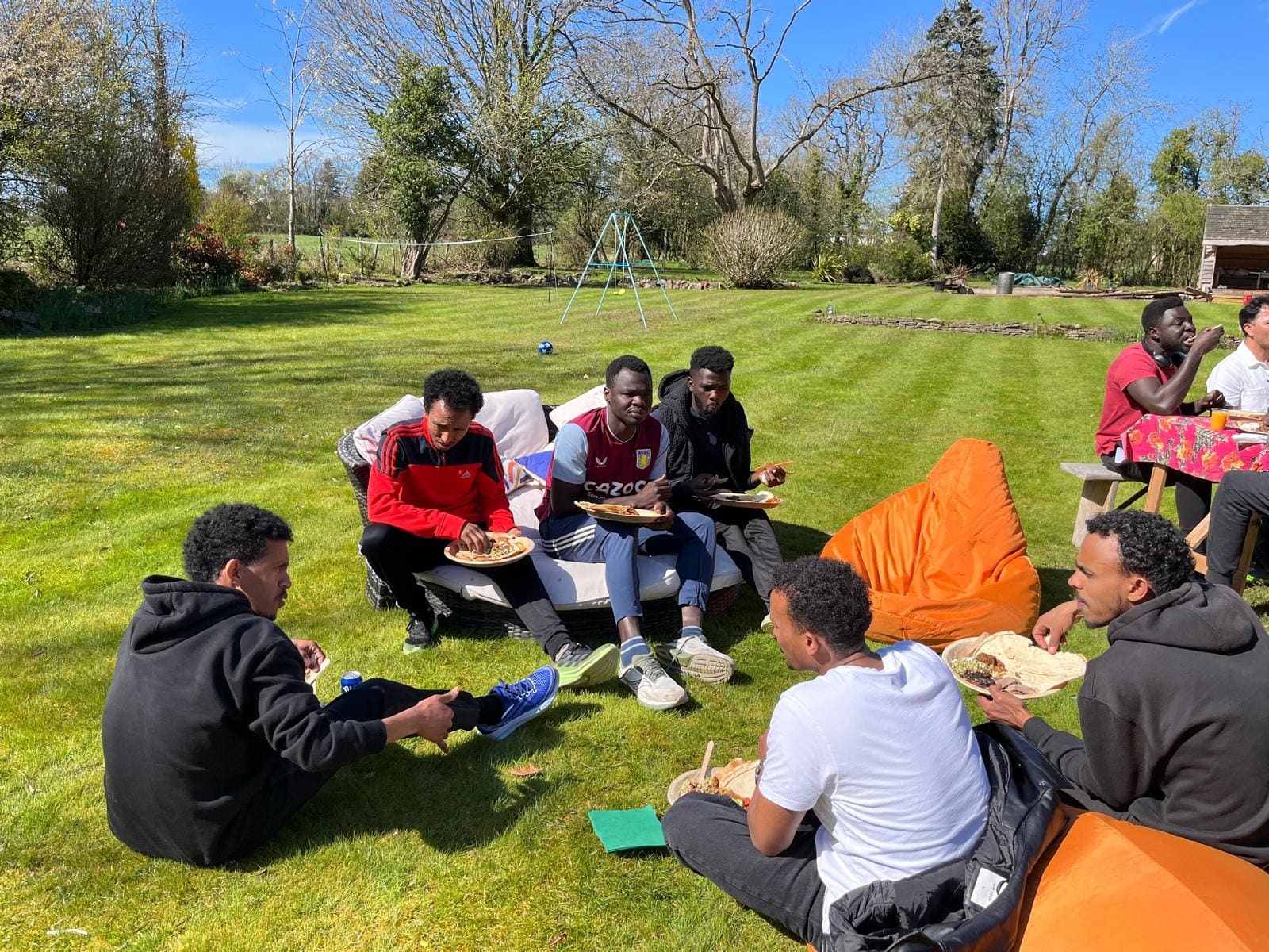 Refugee Run Club members eating together on the lawn