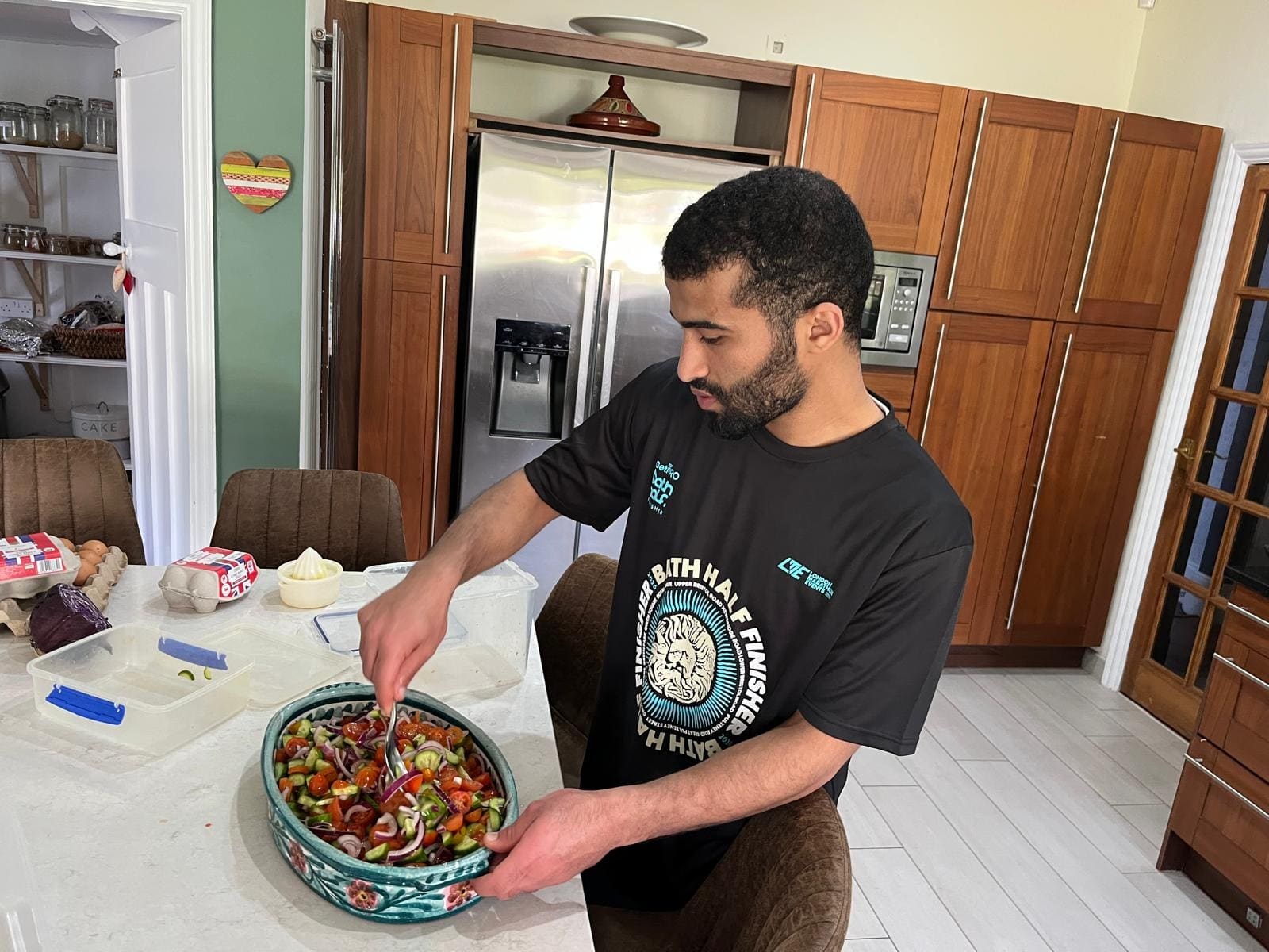 Preparing a big bowl of salad in the kitchen